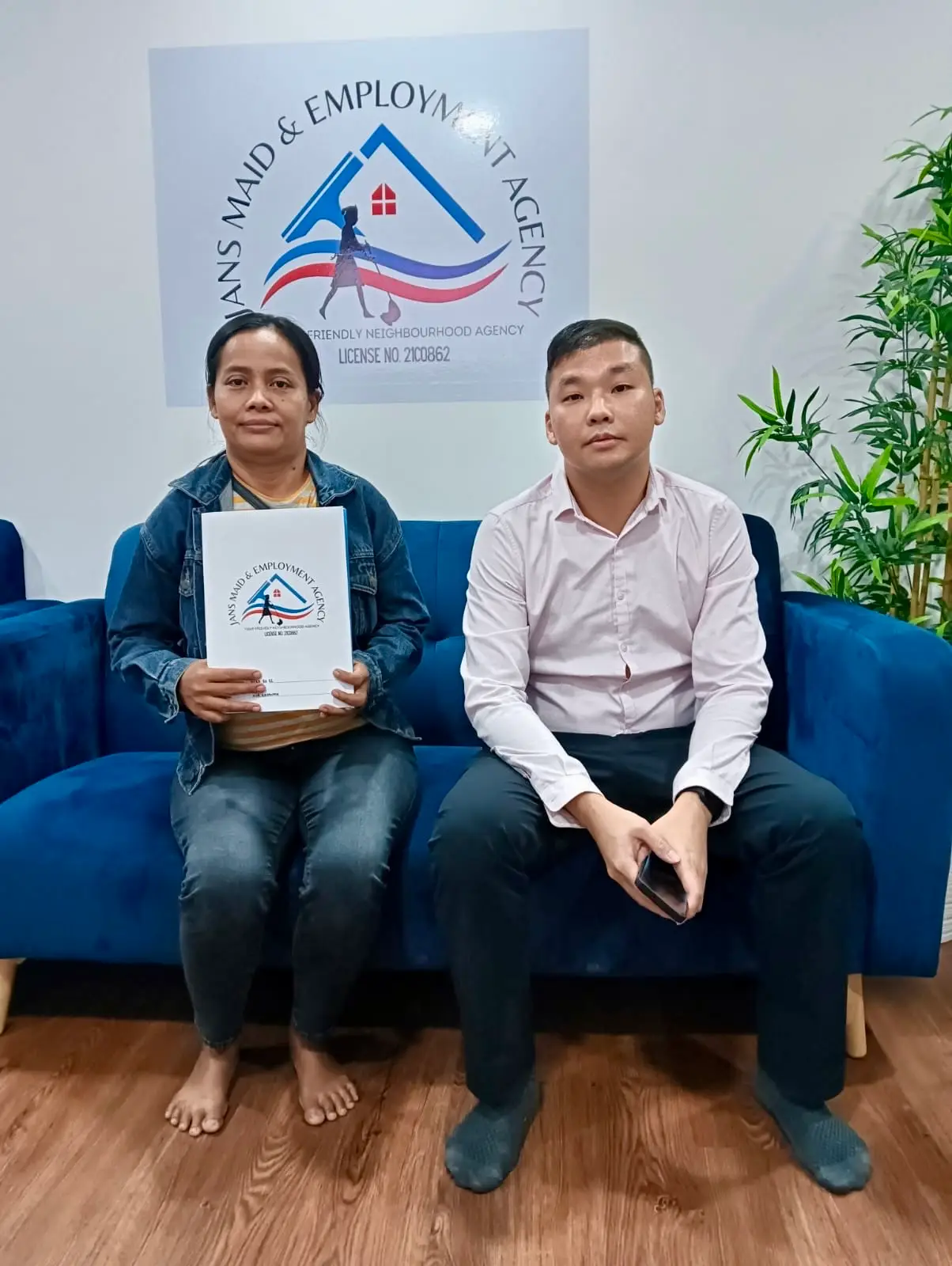 Smiling maid agency Singapore client family holding agreement